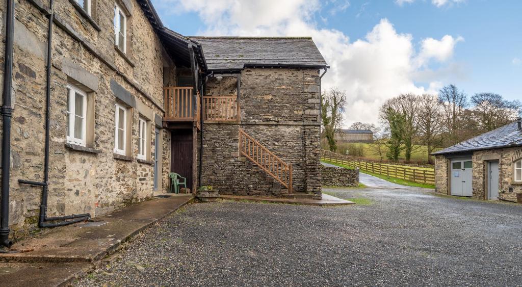 an old stone house with a wooden gate on the side at Ullswater at the Graythwaite Estate in Ambleside