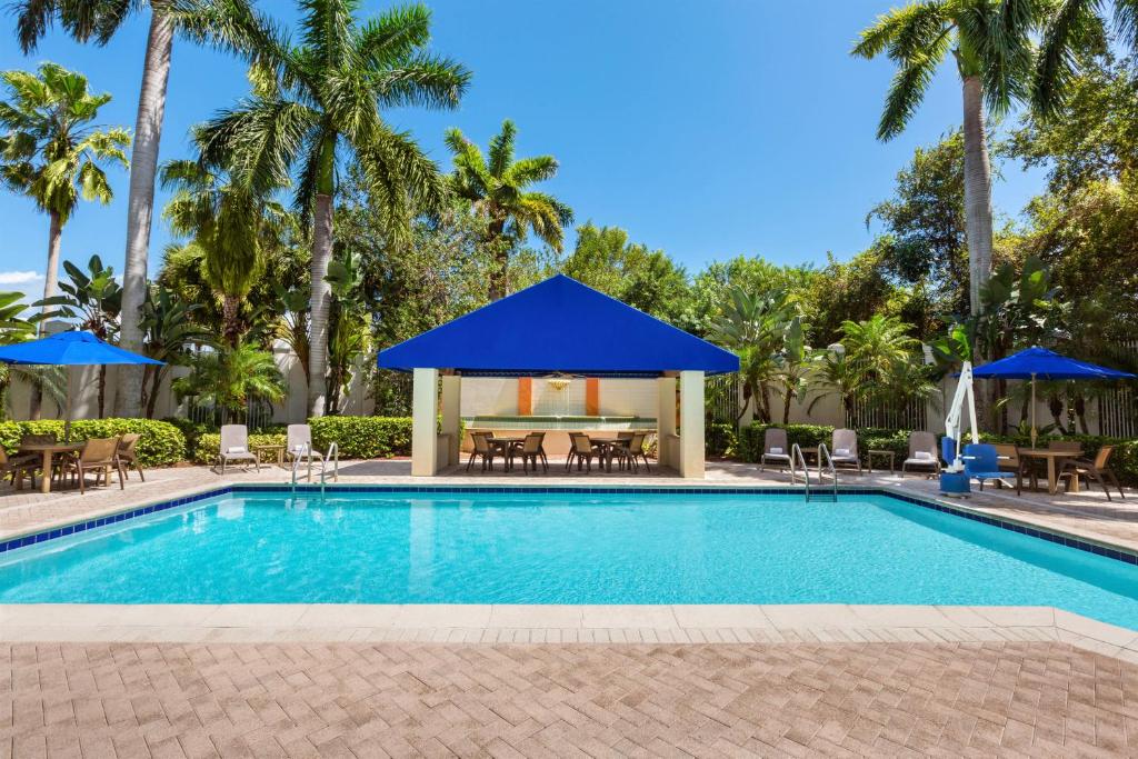 uma piscina com um gazebo e palmeiras em SpringHill Suites Boca Raton em Boca Raton