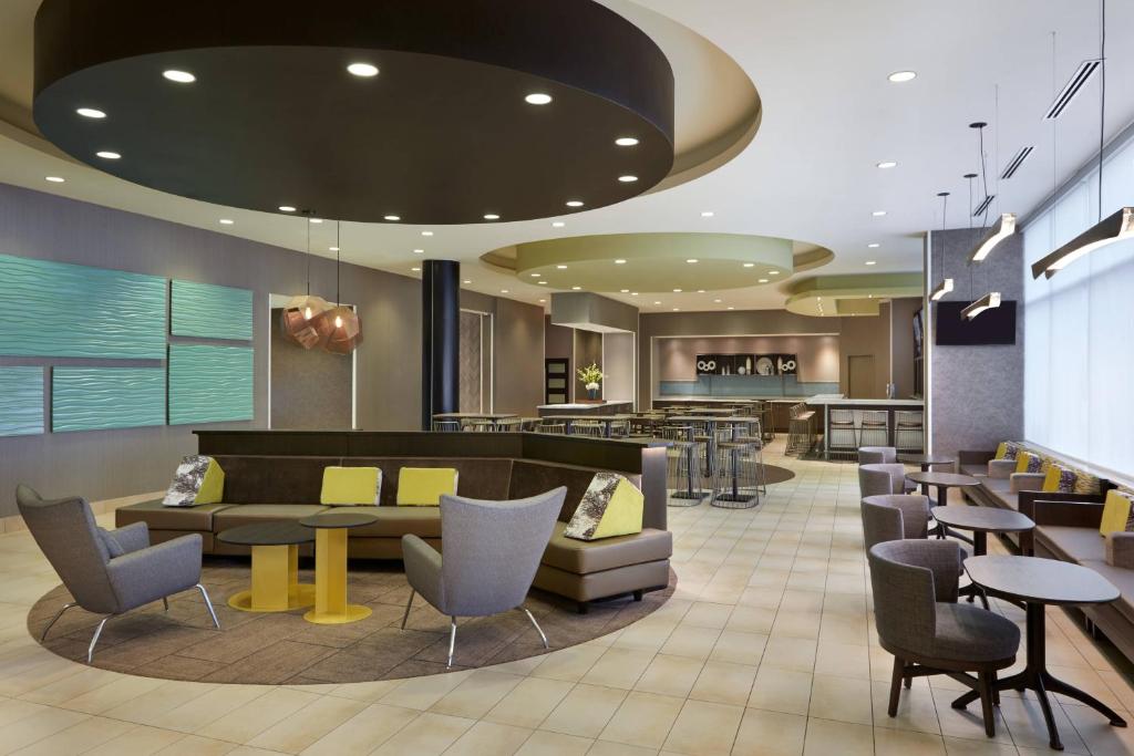 a lobby of a hotel with tables and chairs at SpringHill Suites by Marriott Toronto Vaughan in Vaughan