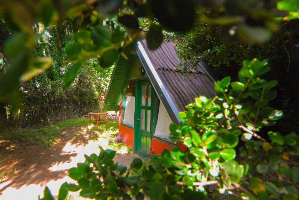 una pequeña casa verde y roja con techo verde en Cabañas La Inesita en San Carlos de Bariloche