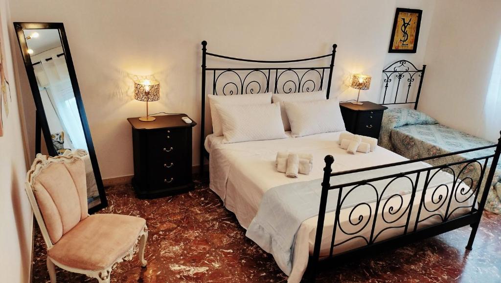 a bedroom with a large bed and a chair at LA BARONESSA apartment- vicinissimo al policlinico in Messina