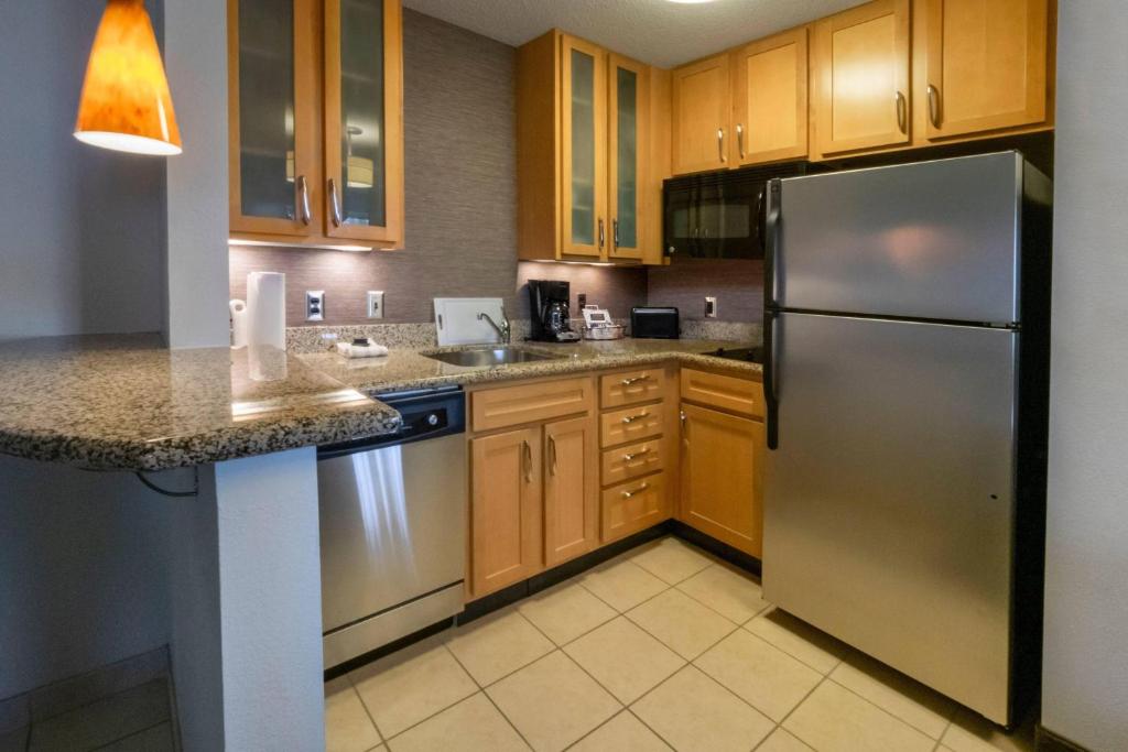 a kitchen with wooden cabinets and a stainless steel refrigerator at Residence Inn by Marriott Hazleton in Hazleton