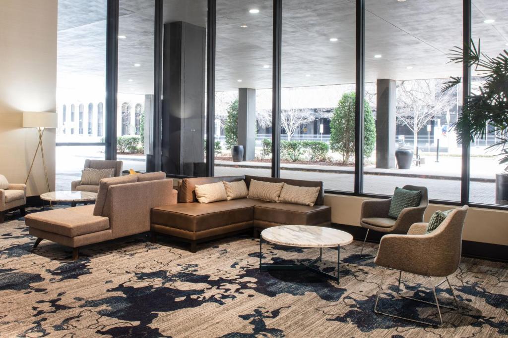 een lobby met een bank, stoelen en ramen bij Sheraton Oklahoma City Downtown Hotel in Oklahoma City