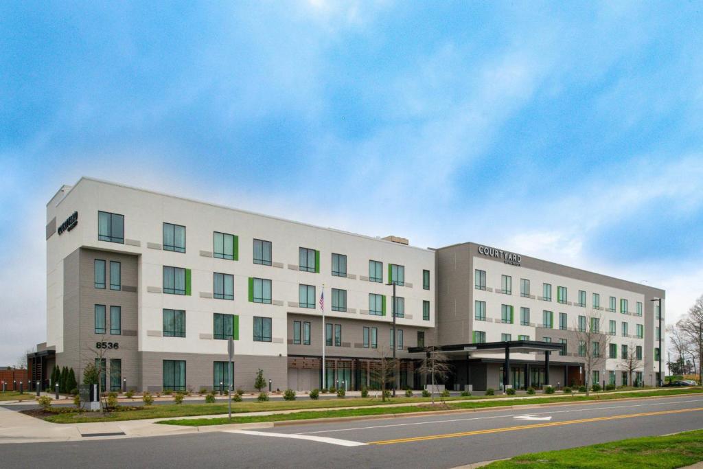 a large white building on the side of a street at Courtyard Charlotte Steele Creek in Charlotte