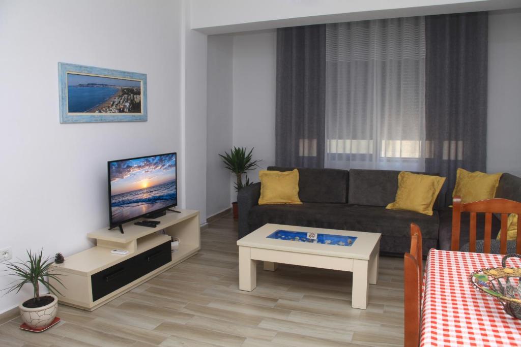 a living room with a couch and a tv at Old town boulevard apartment in city center in Durrës