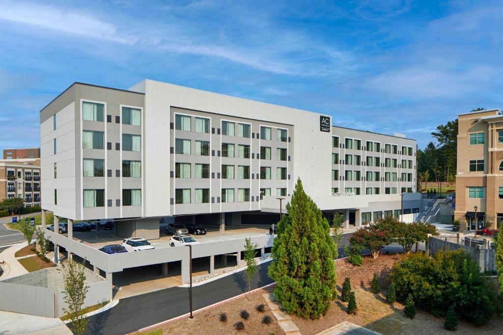 a large white building with cars parked outside of it at AC Hotel by Marriott Durham in Durham