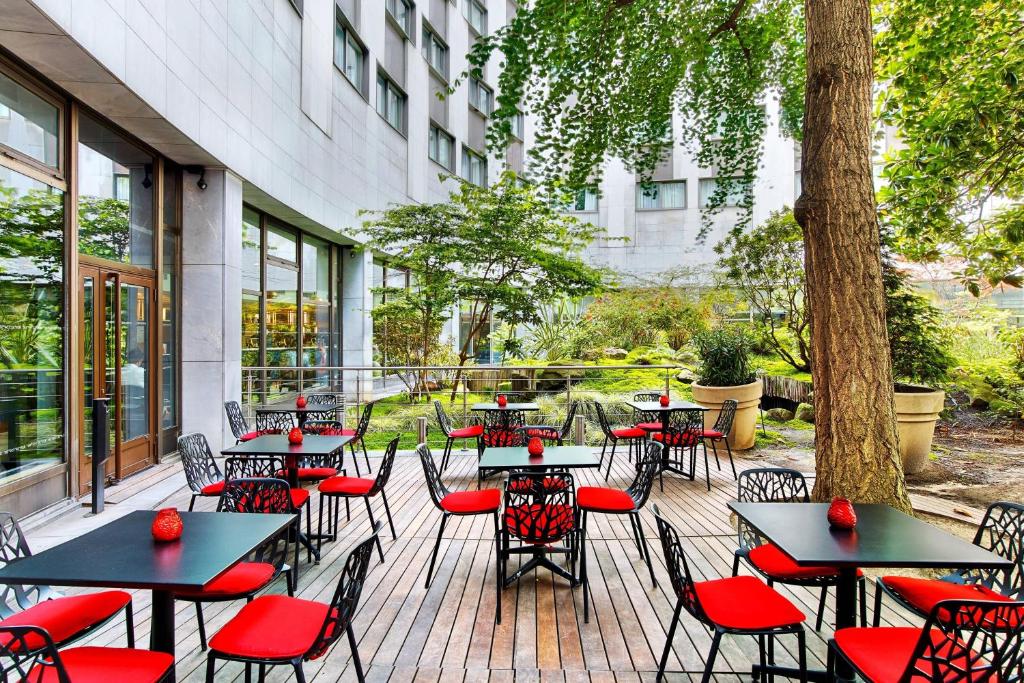 a patio with tables and chairs in front of a building at Le M&eacute;ridien Etoile in Paris