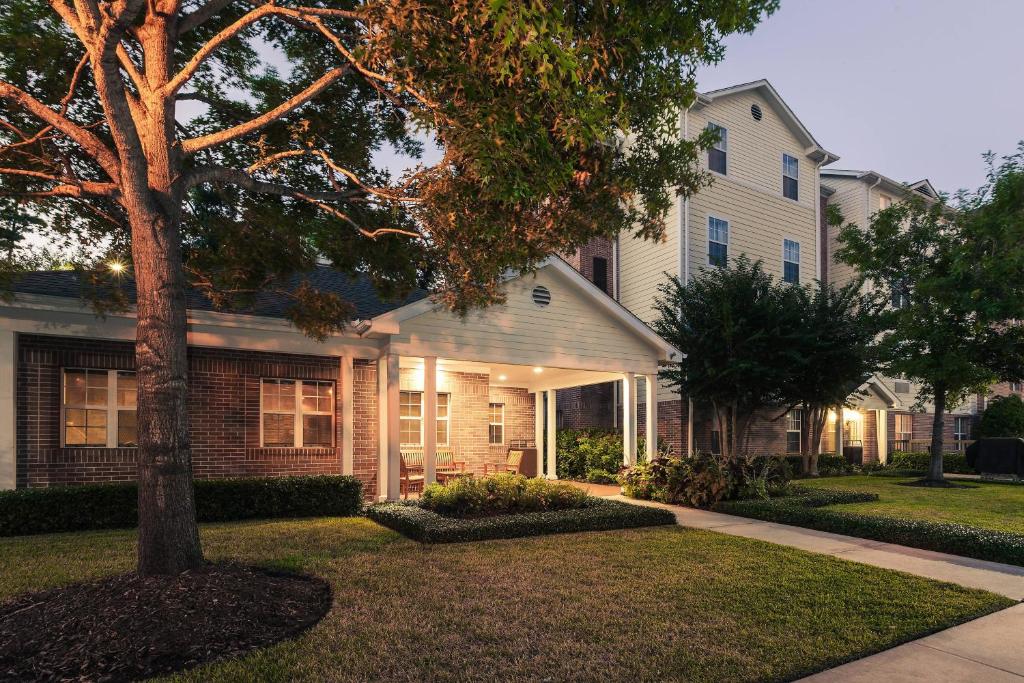 TownePlace Suites Houston Northwest في هيوستن: منزل به شجرة في الفناء الأمامي