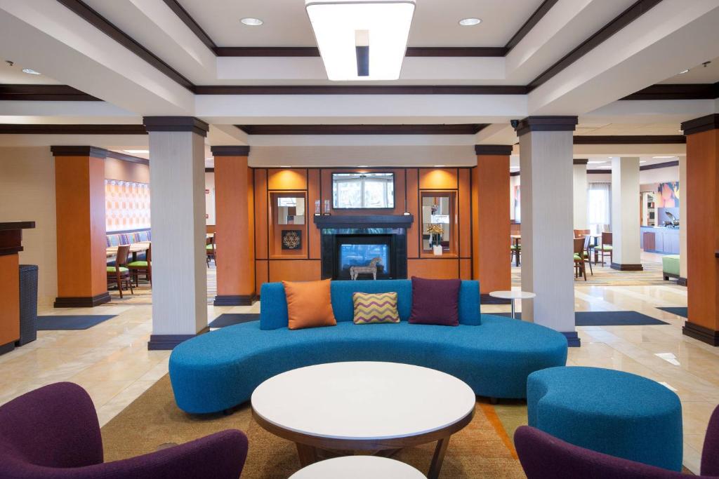 a lobby with a blue couch and tables and chairs at Fairfield Inn & Suites Orange Beach in Orange Beach