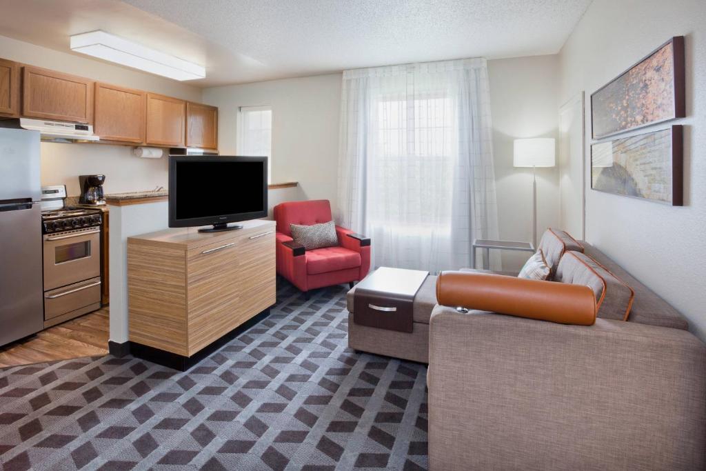 a living room with a couch and a tv and a kitchen at TownePlace Suites Minneapolis Eden Prairie in Eden Prairie