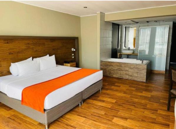 um quarto com uma cama grande e uma casa de banho em HOTEL POLO CORPORATIVO SAN SEBASTIAN em Cusco