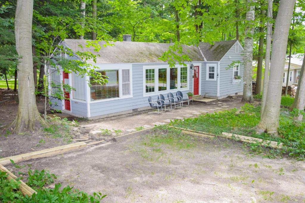 een wit huis met een rode deur in het bos bij Cottage Living in Beulah