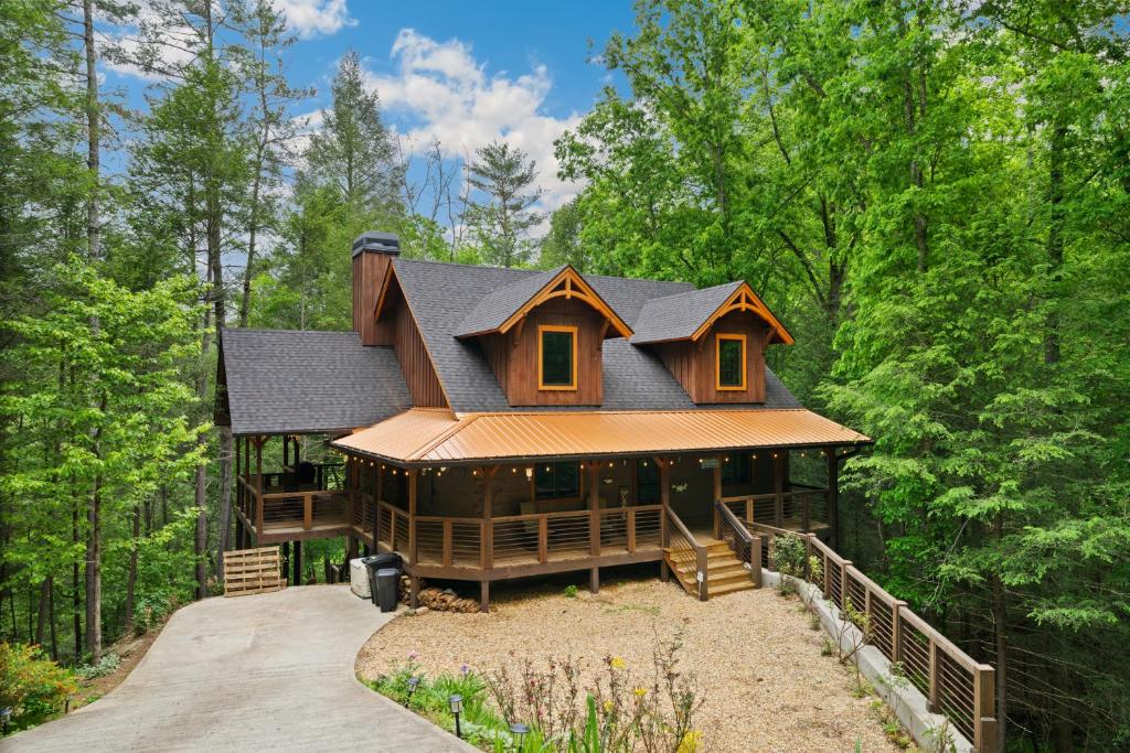 a large house in the woods with a driveway at Tranquil Waters Cabin in Ellijay