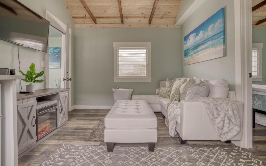 Una sala de estar con un sofá blanco y un televisor. en Beach Bliss - Meredith Lodging, en Rockaway Beach