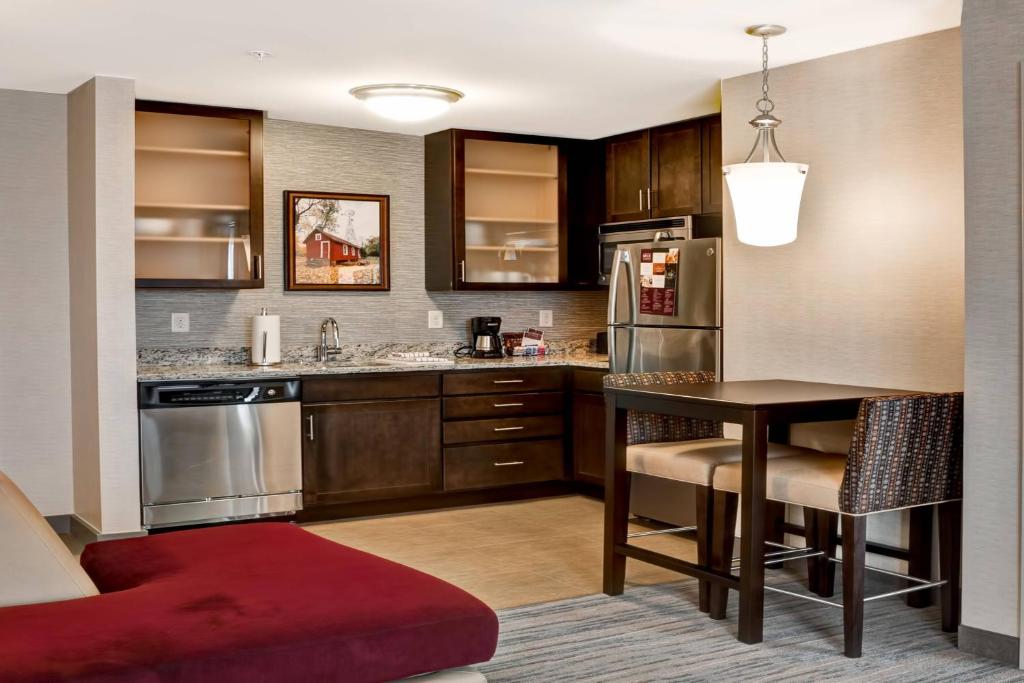 a kitchen with a table and a dining room at Residence Inn by Marriott Hamilton in Hamilton