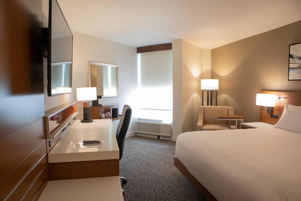 a hotel room with a bed and a desk at Delta Hotels by Marriott Allentown Lehigh Valley in Fogelsville