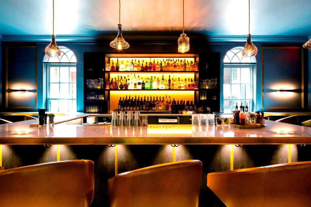 a bar with a large wooden table and chairs at Morrison House Old Town Alexandria, Autograph Collection in Alexandria