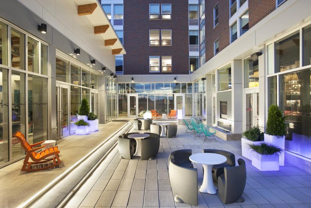 an empty lobby of a building with tables and chairs at Aloft Syracuse Inner Harbor in Syracuse