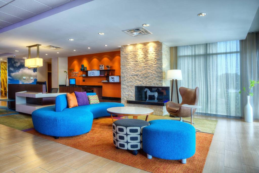 a living room with blue furniture and a fireplace at Fairfield Inn & Suites by Marriott Austin San Marcos in San Marcos