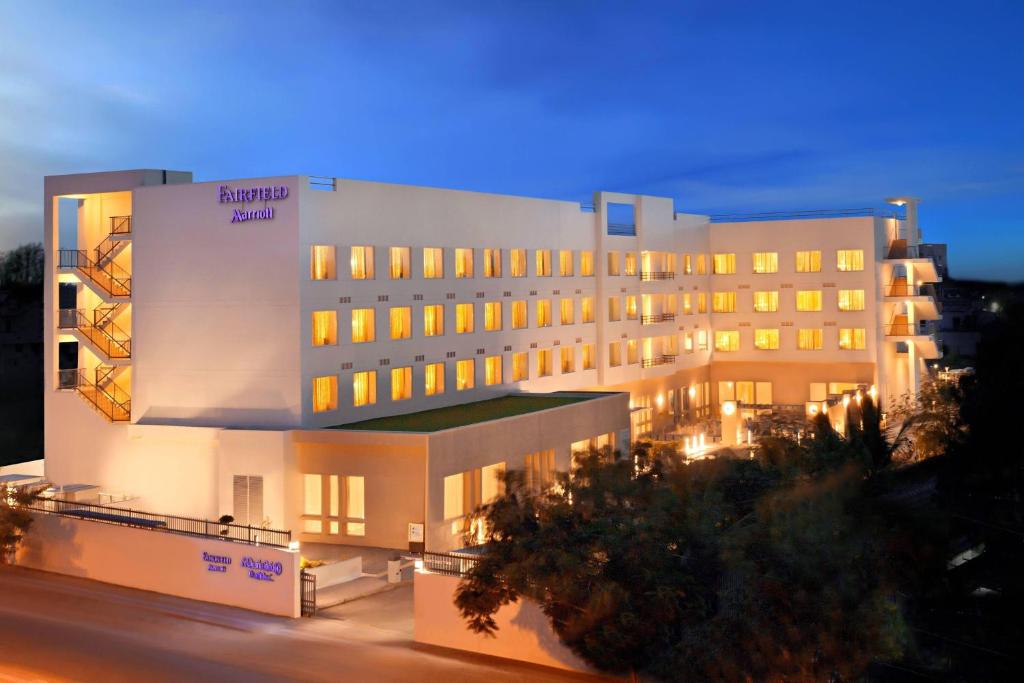 a hotel building with a lit up facade at night at Fairfield by Marriott Coimbatore in Coimbatore