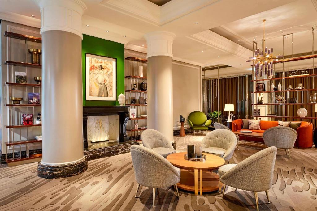 a living room with chairs and a table and a fireplace at The Ritz-Carlton, Berlin in Berlin