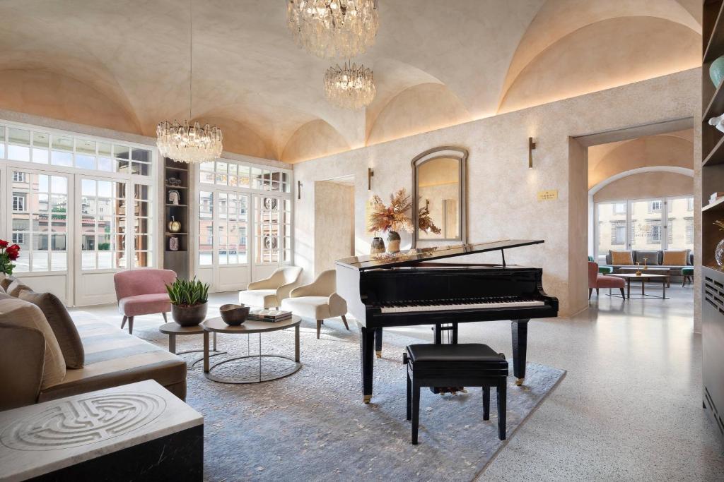 a living room with a piano in the middle at Grand Universe Lucca, Autograph Collection in Lucca