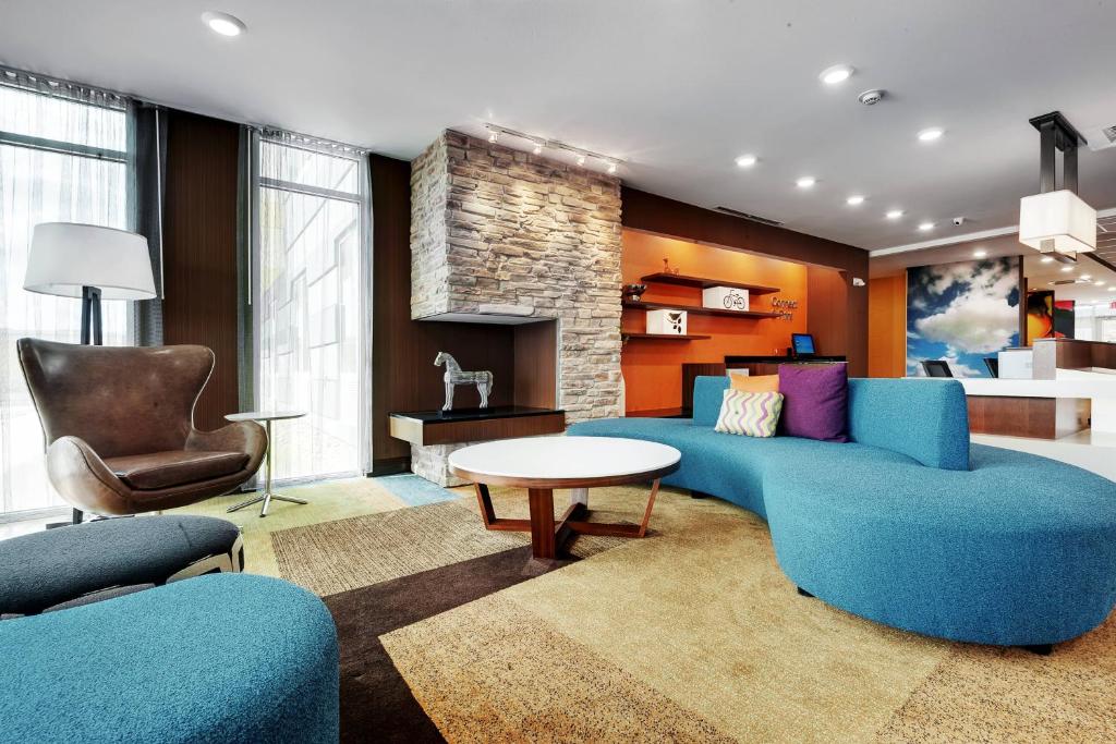 uma sala de estar com um sofá azul e uma mesa em Fairfield Inn by Marriott Houston Northwest/Willowbrook em Houston