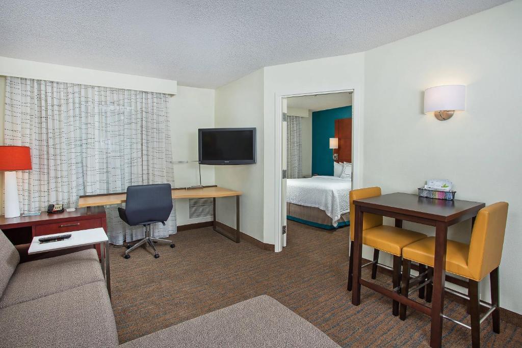 a hotel room with a room with a bed and a desk at Residence Inn Knoxville Cedar Bluff in Knoxville