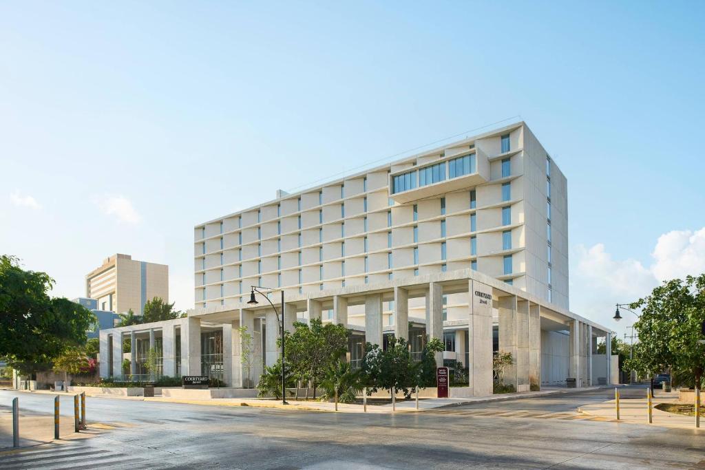 un grand bâtiment blanc avec une rue en face dans l'établissement Courtyard by Marriott Merida Downtown, à Mérida