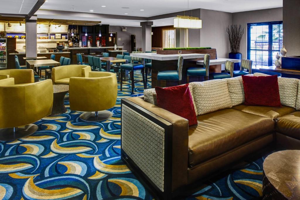 eine Lobby mit einem Sofa, Tischen und Stühlen in der Unterkunft Courtyard by Marriott New Bern in New Bern