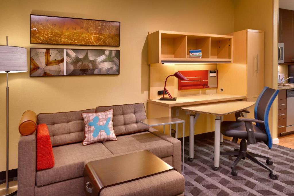 a living room with a couch and a table and a desk at TownePlace Suites by Marriott Dickinson in Dickinson