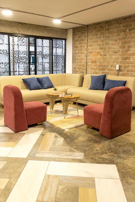 a living room with a couch and two chairs at Ventiuna Hotel y Coliving in Pereira