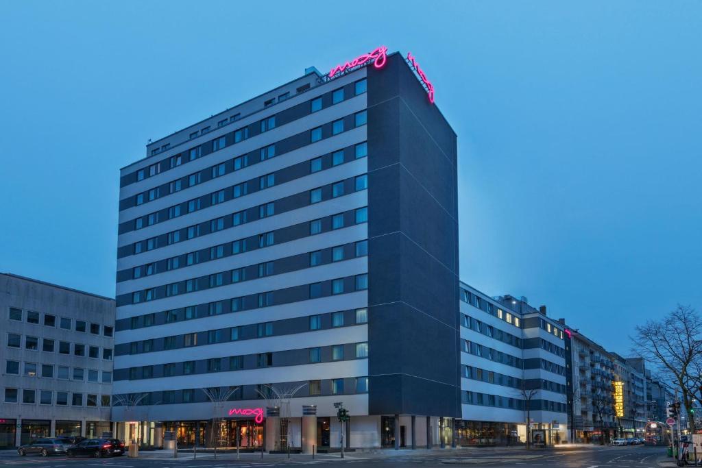 a tall black building with a red sign on top at Moxy Duesseldorf City in Düsseldorf
