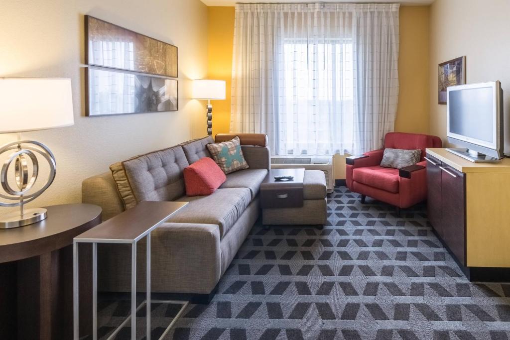 a living room with a couch and a tv at TownePlace Suites Dayton North in Dayton