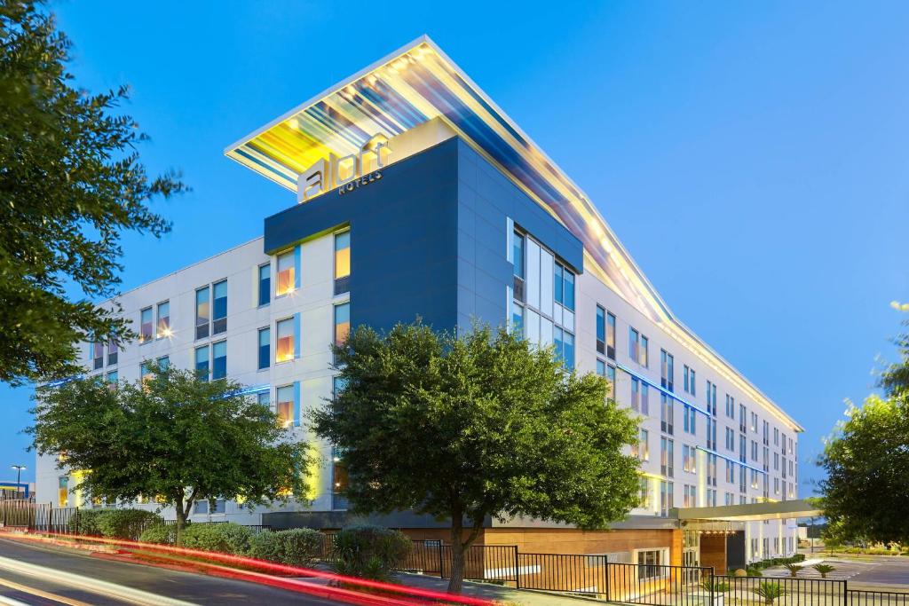 un edificio de apartamentos de color azul y blanco en Aloft San Antonio Airport, en San Antonio