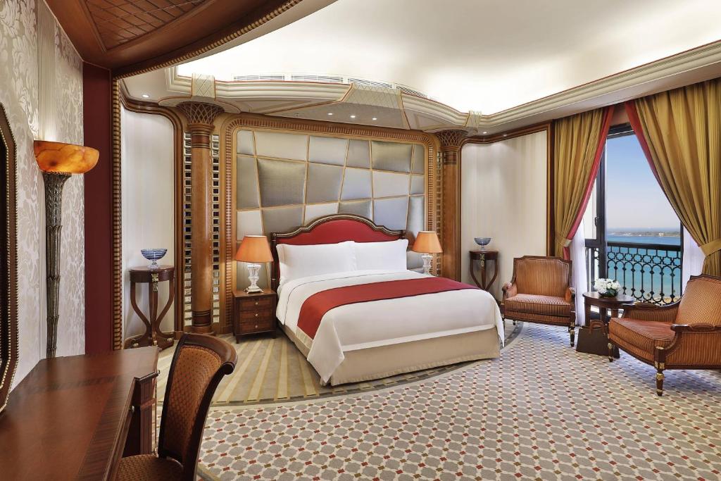 a bedroom with a bed and a desk and a balcony at The Ritz-Carlton Jeddah in Jeddah