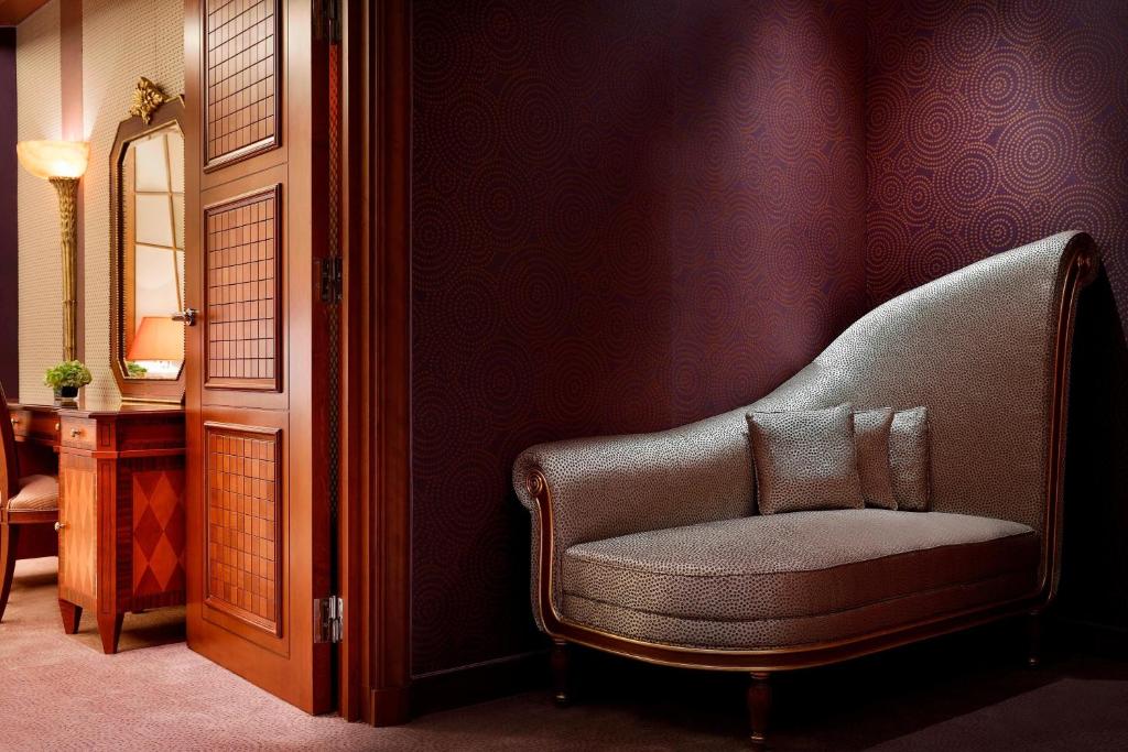 a living room with a chair and a mirror at The Ritz-Carlton Jeddah in Jeddah