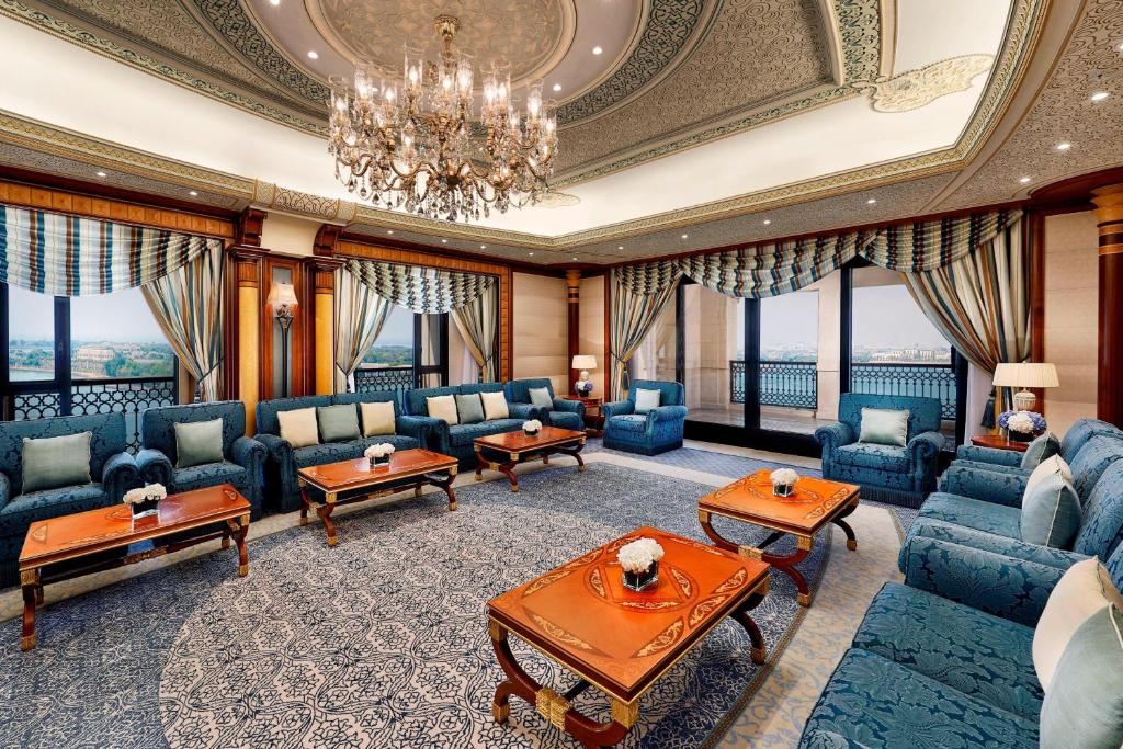 a large living room with blue furniture and windows at The Ritz-Carlton Jeddah in Jeddah