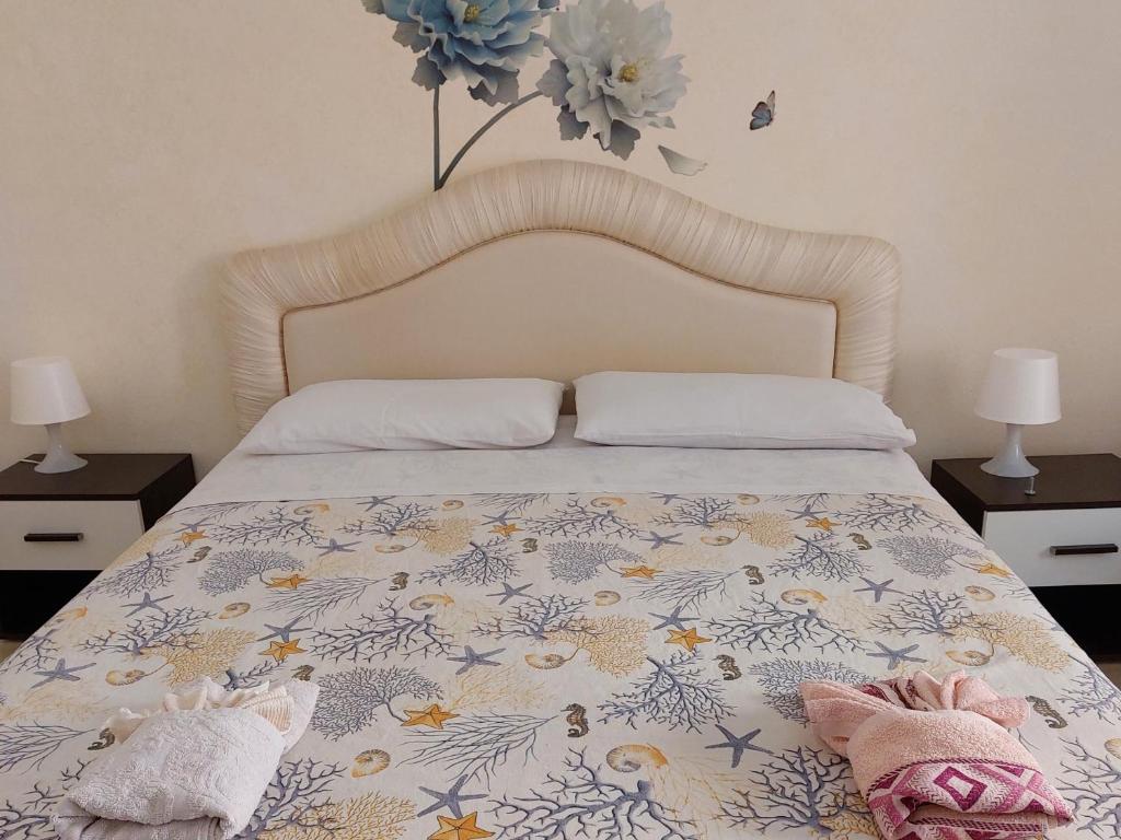 1 dormitorio con 1 cama con colcha de flores en Casa Ortigia, en Siracusa