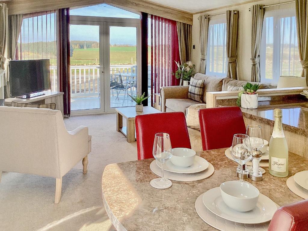 uma sala de estar com uma mesa com copos de vinho em Ballagan Lodge em Leanach