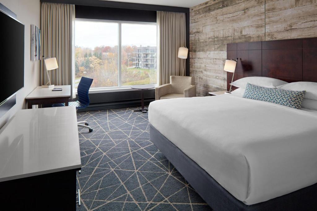 Habitación de hotel con cama grande y ventana grande. en Delta Hotels by Marriott Sherbrooke Conference Centre, en Sherbrooke