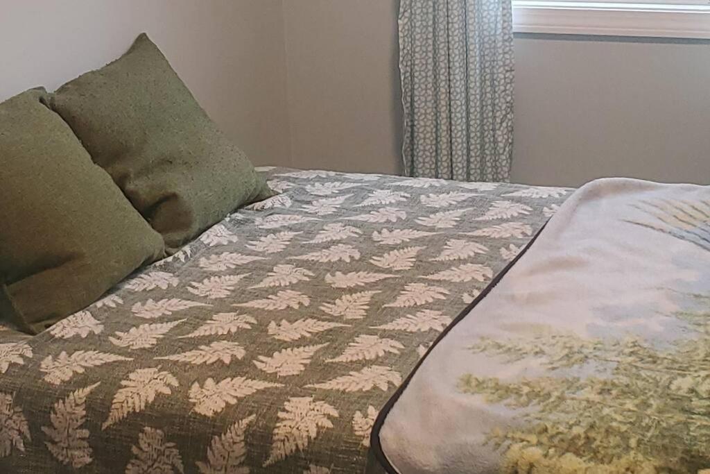 a bed with a blanket and two pillows on it at Adorable 1 bedroom with off-street parking 
