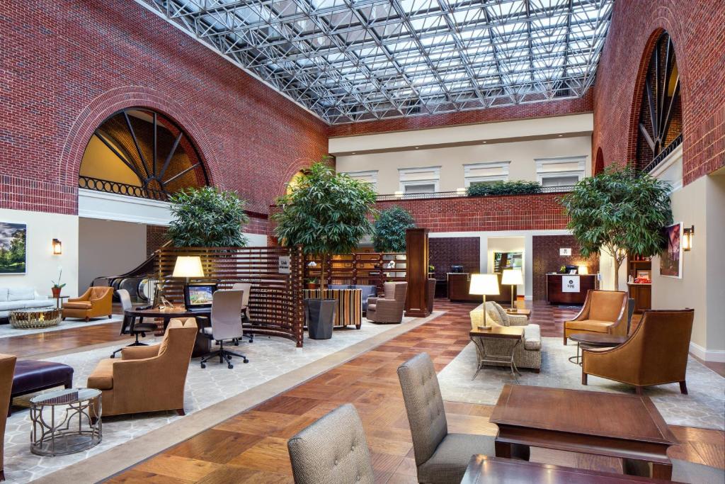 a lobby of a library with tables and chairs at Sheraton Raleigh Hotel in Raleigh