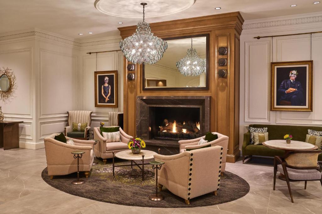a living room with a fireplace and a chandelier at The Whitley, a Luxury Collection Hotel, Atlanta Buckhead in Atlanta