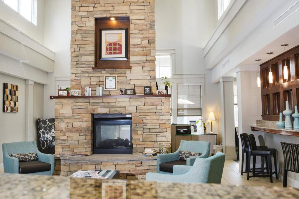 a living room with a stone fireplace with blue chairs at Residence Inn Paducah in Paducah