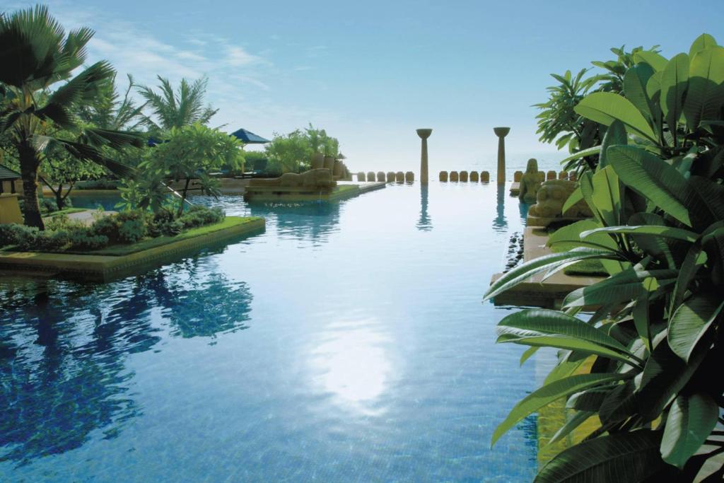 einen Pool in einem Resort mit Bäumen und Wasser in der Unterkunft JW Marriott Mumbai Juhu in Mumbai