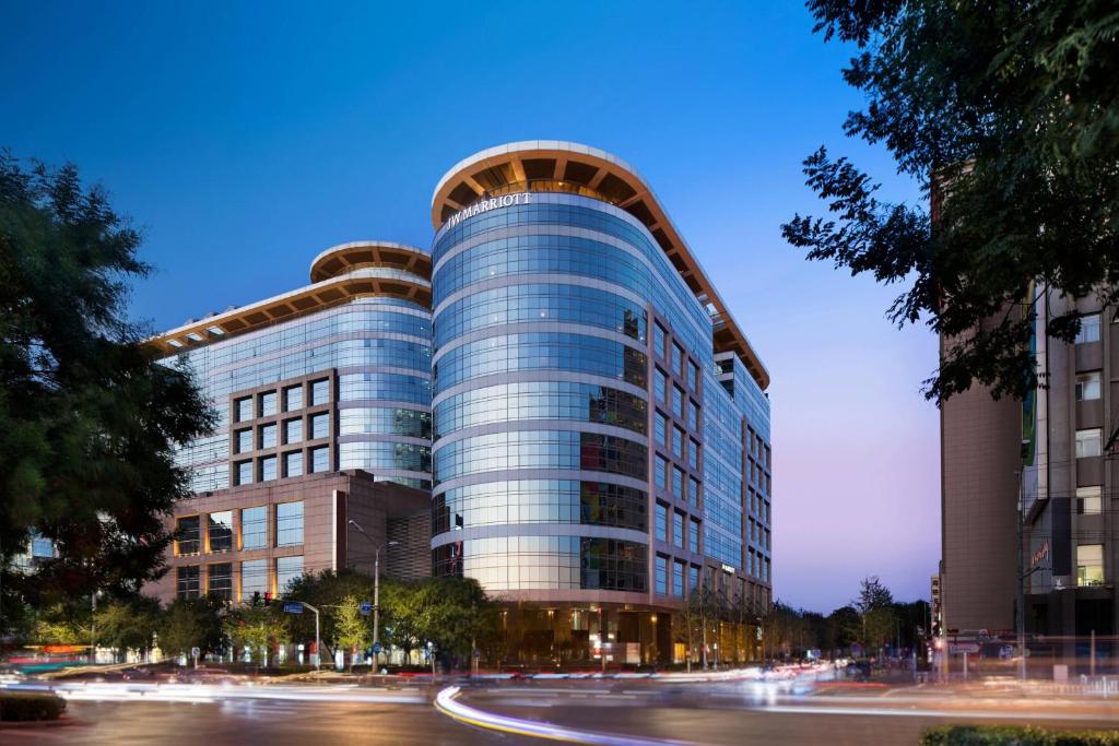 a tall glass building with a curved roof at JW Marriott Hotel Beijing Central in Beijing