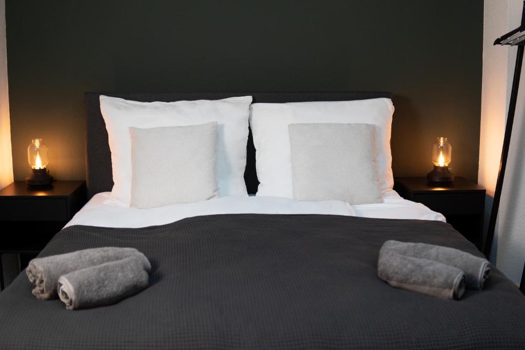 a bedroom with a bed with two pillows and two lamps at Business & Family - Zentral, 24h Check-In, XXL TV in Siegburg