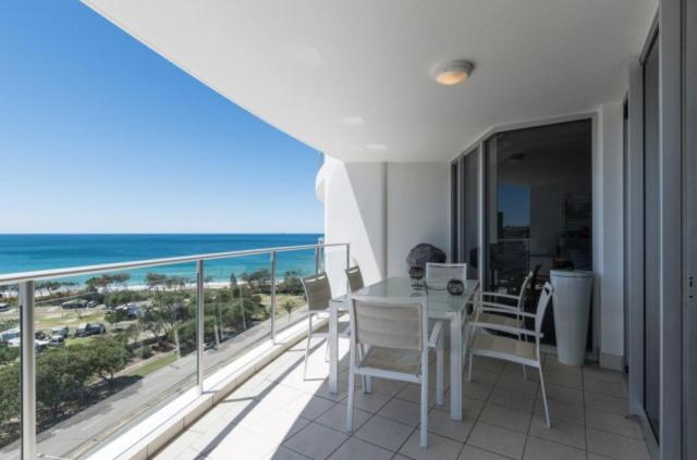 a balcony with a table and chairs and the ocean at Resort Apartment with Ocean Views in Maroochydore