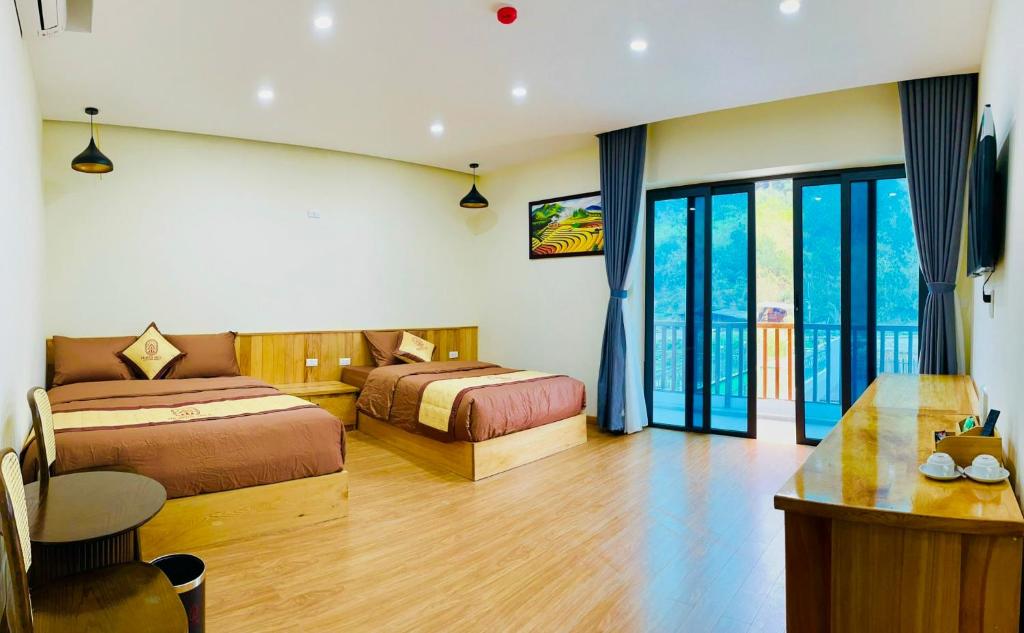 a hotel room with two beds and a desk at Heaven Hill Hotel & Hot Spring in Cham Ta Lao